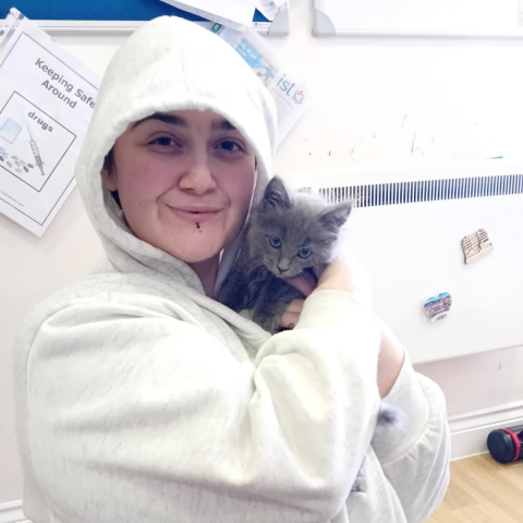 Bolton Client holds her new pet, a small grey fluffy kitten