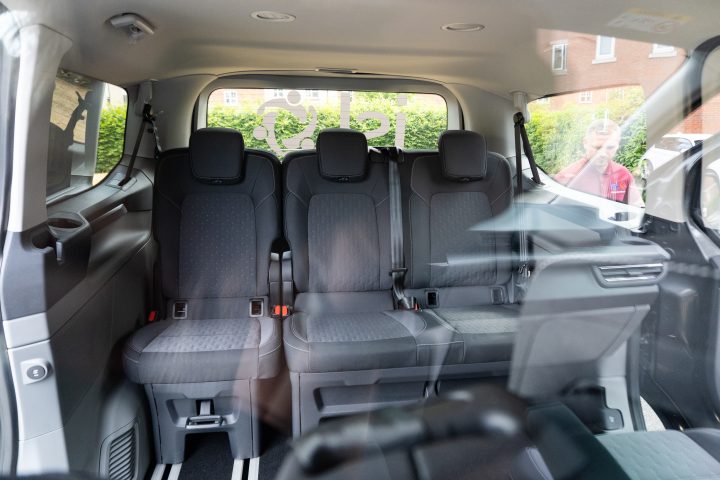 Back seats of the secure new vehicle shown through protective screen from the front seats. 